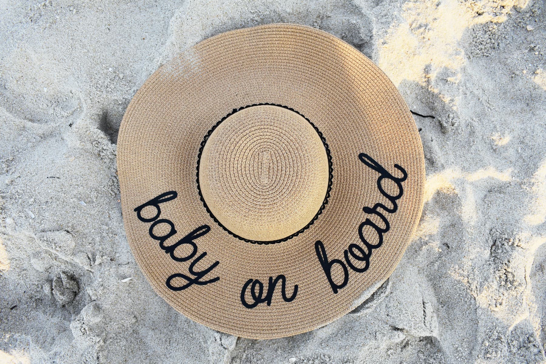 A lady's hat with messaging that says "baby on board"