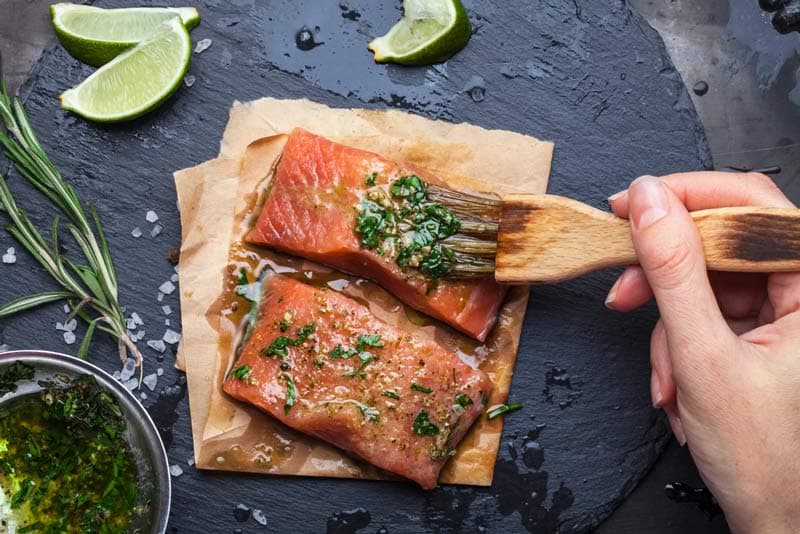 Salmon on a chopping board being marinated