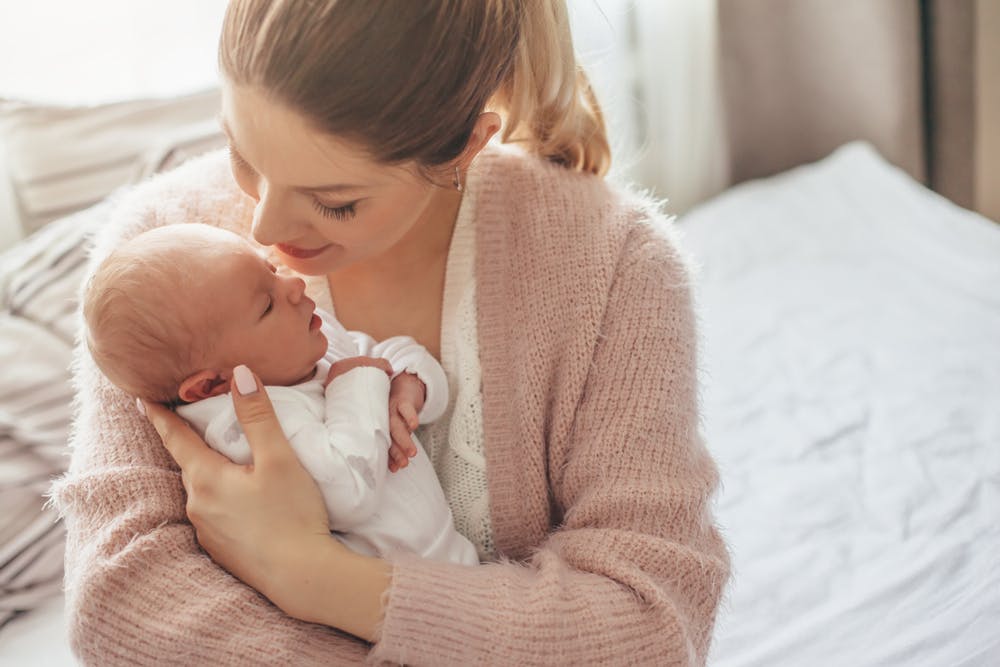 A mother holding a new born baby in her arms