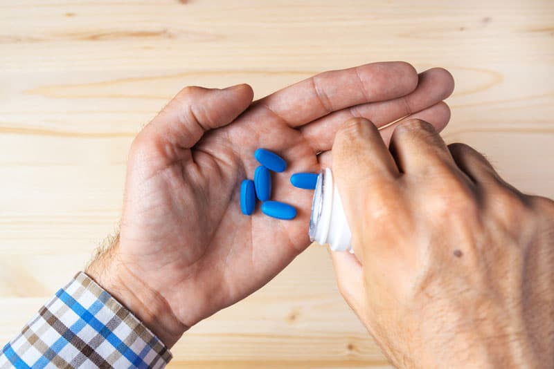 A man holding Levitra (Vardenafil) tablets in the palm of his hand