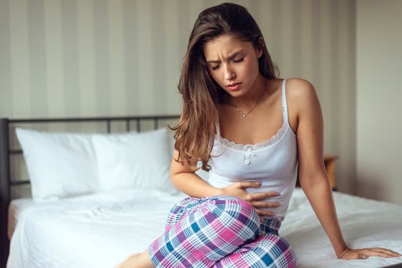 A lady clutching her stomach in pain because of her period pains