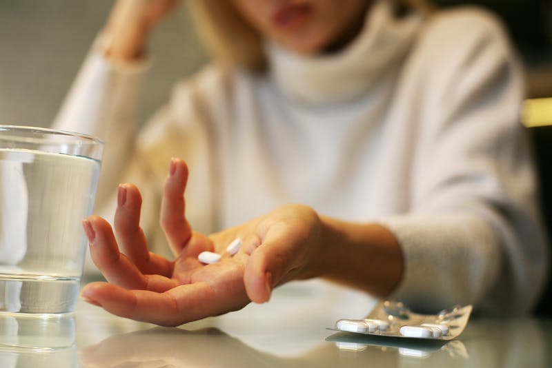 A lady holding Naproxen in her hands