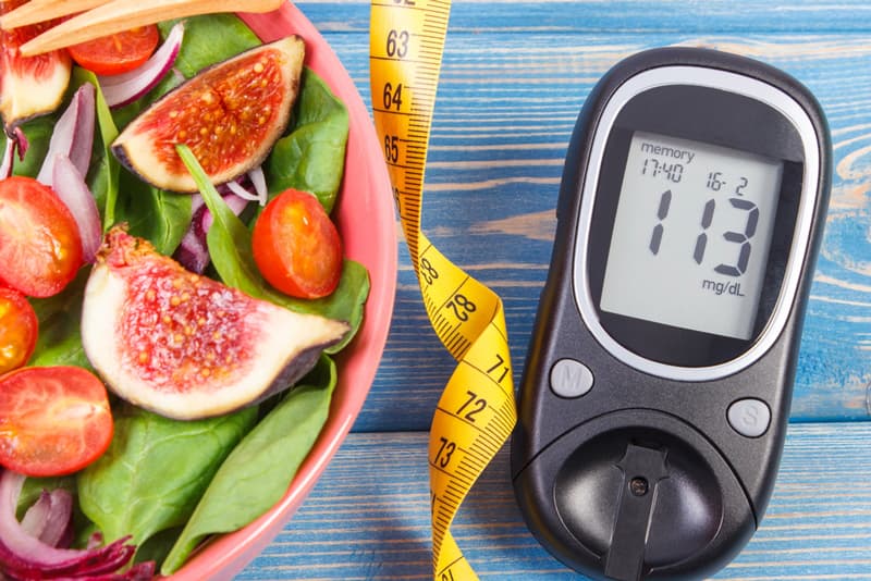 Fruits and vegetables next to a tape measure and weight scale