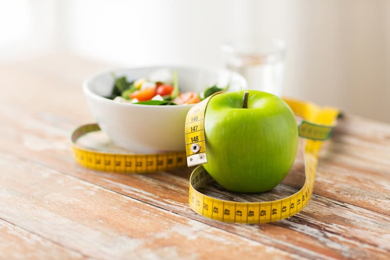 An apple with a tape measure around it