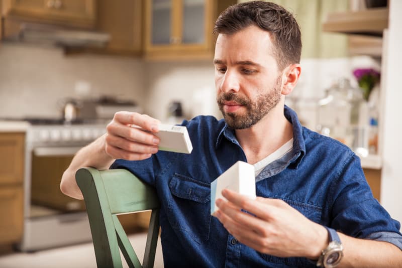 A man reading the packaging for Levitra tablets