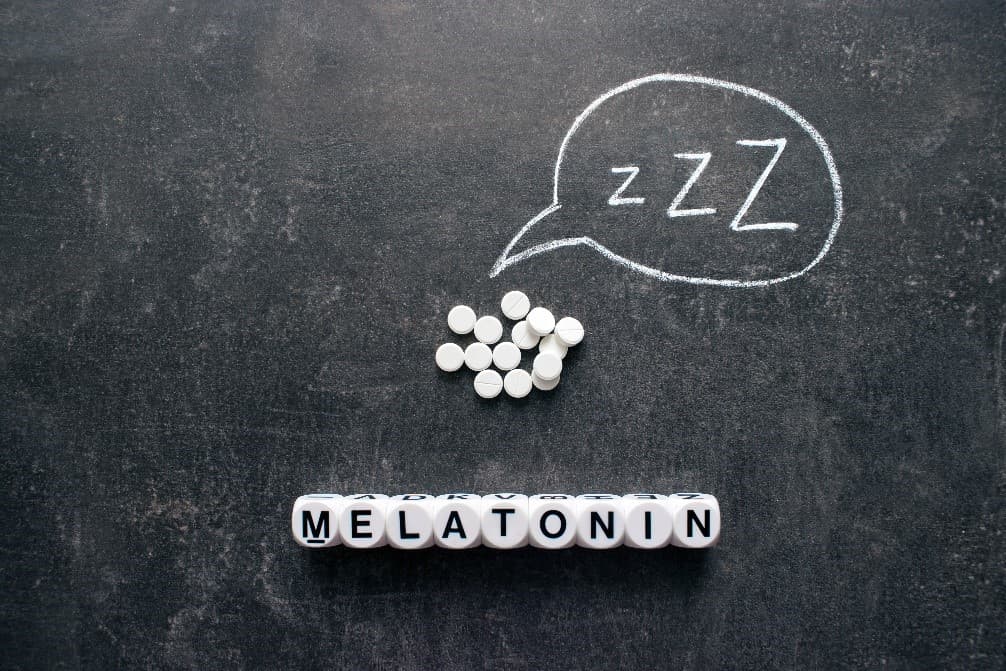 A series of dice that spell out the word 'melatonin' with some Circadin tablets above it