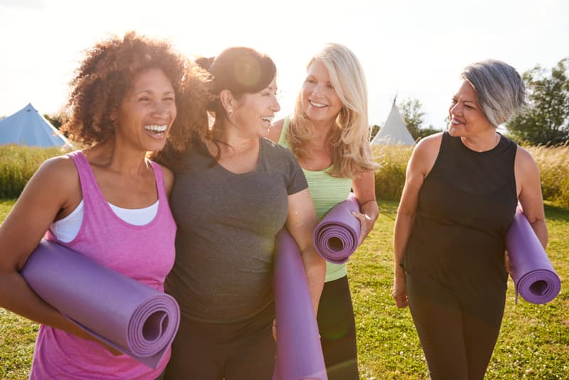 A group of middle aged women exercising in the park together and looking happy
