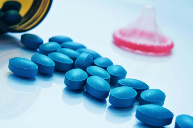 Viagra tablets laid out on a table next to a condom