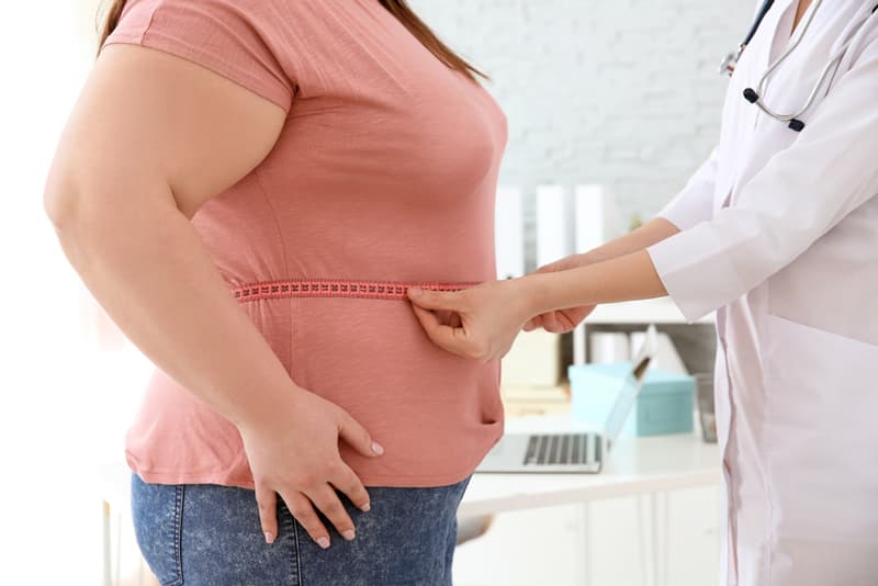An overweight lady being assessed by a doctor