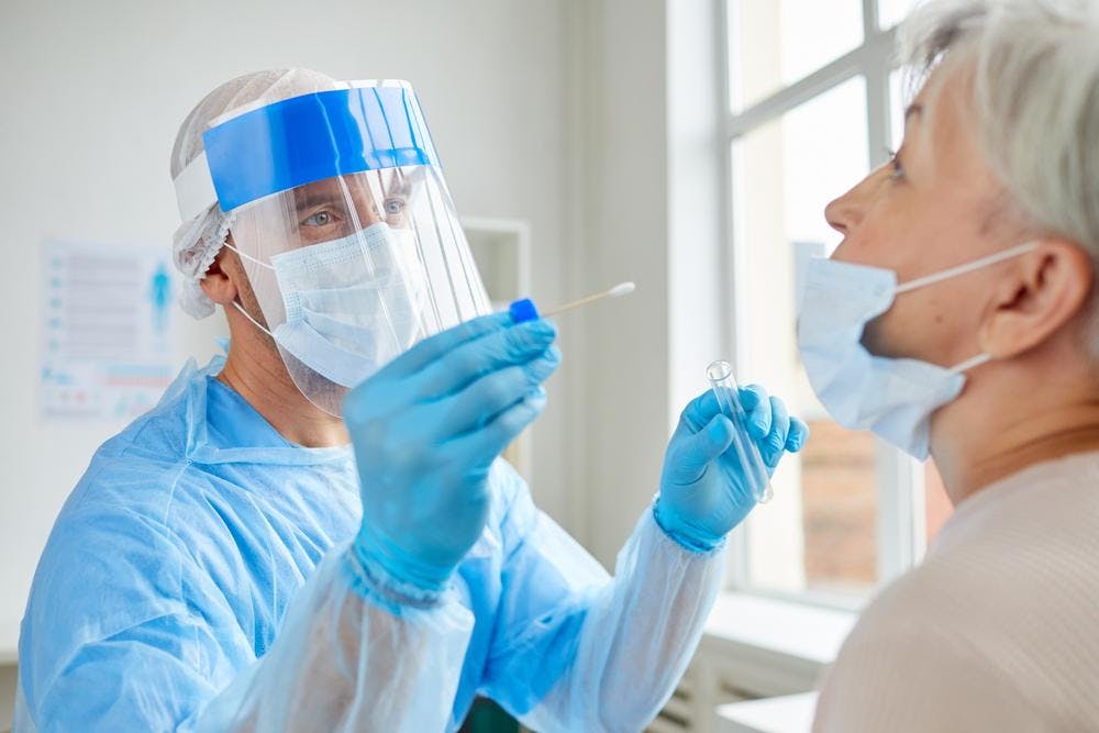 Doctor assessing a patient for COVID using a PCR test