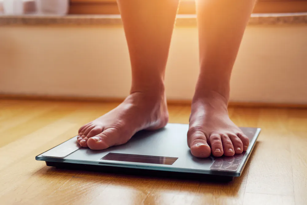 Two feet standing on top of a weighing scale