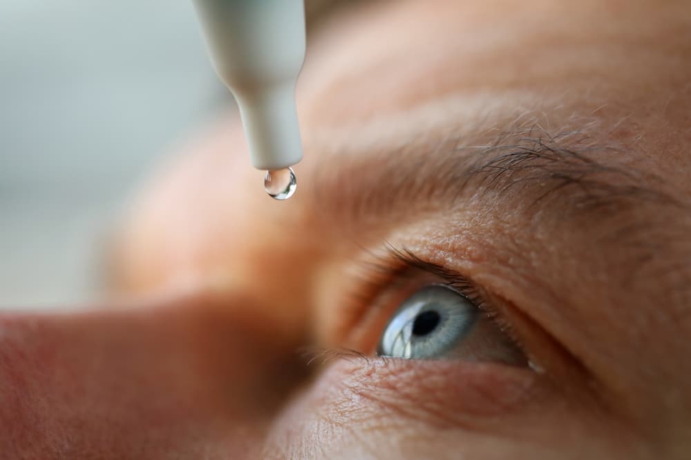 Eye drops being administered to a man's eye