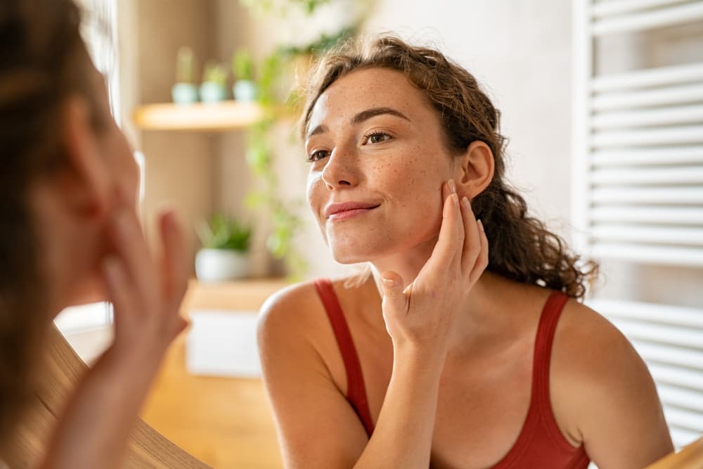 A lady looking at her face acne-free face