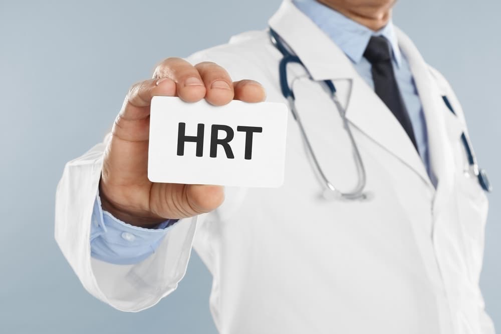 Doctor holding up a card with the acronym HRT on it (to represent Hormone Replacement Therapy)