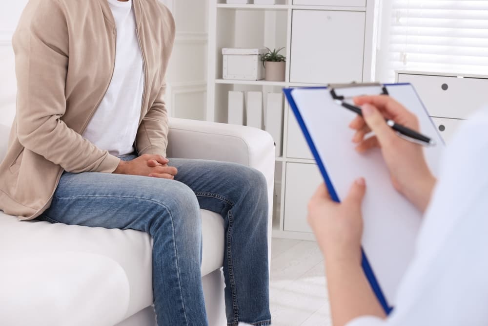 Man sat with a doctor having a consultation about a sexual health problem