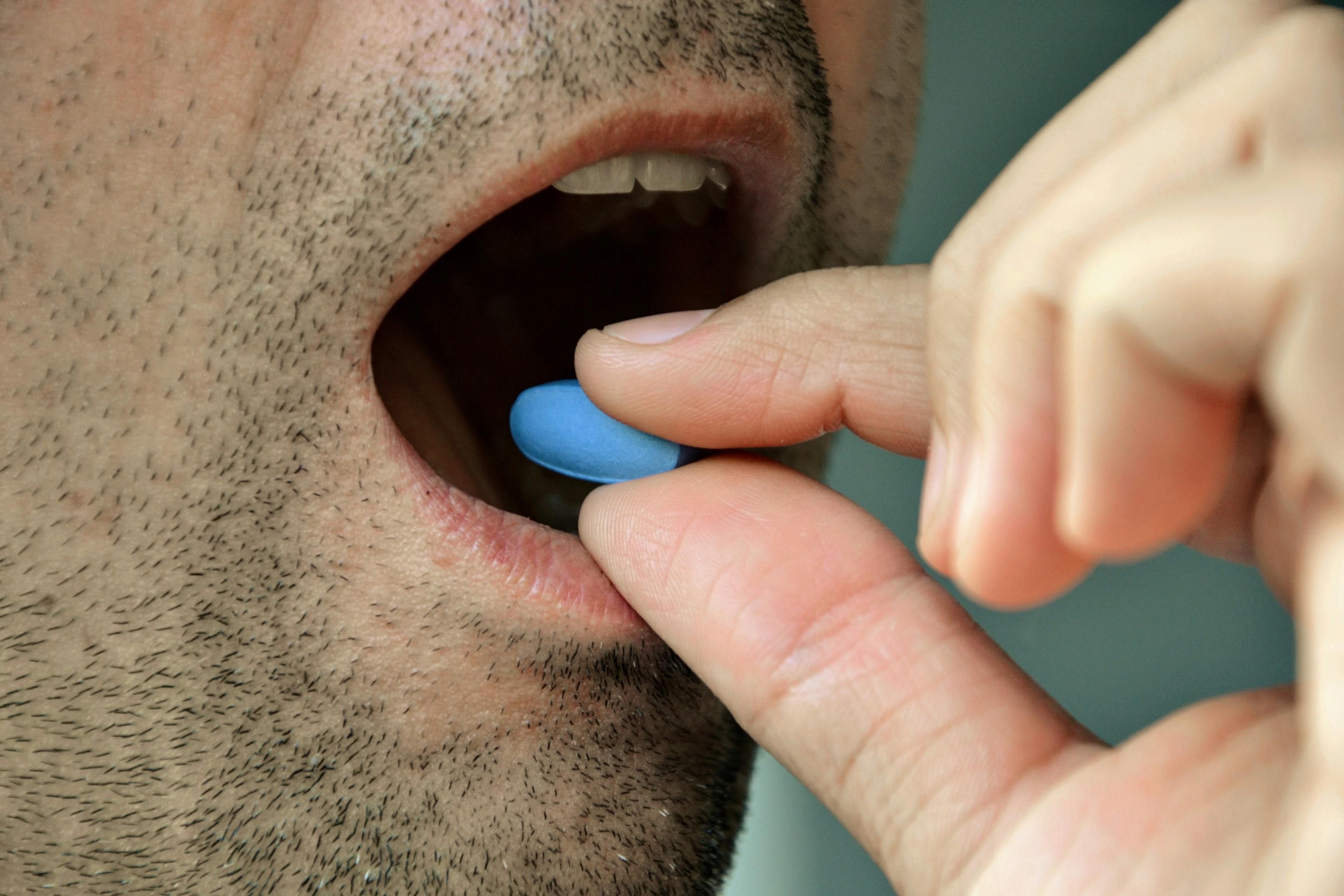 A man taking a Viagra tablet