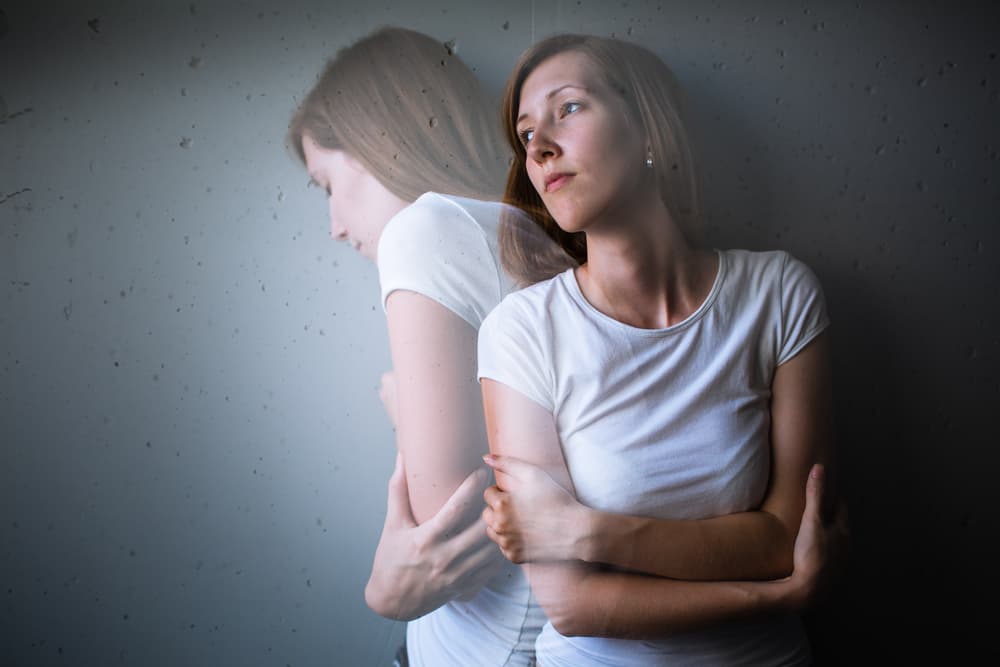 Lady stood against a wall looking upset due to suffering from generalised anxiety disorder (GAD)