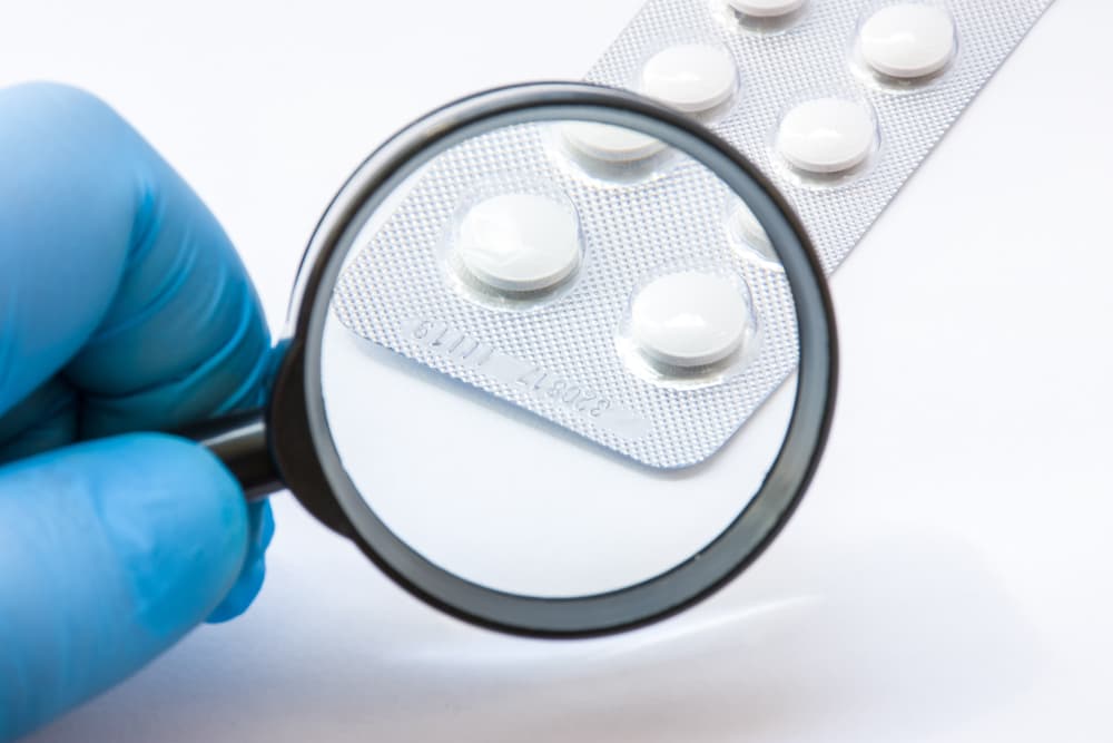 A magnifying glass looking at a packet of medicine