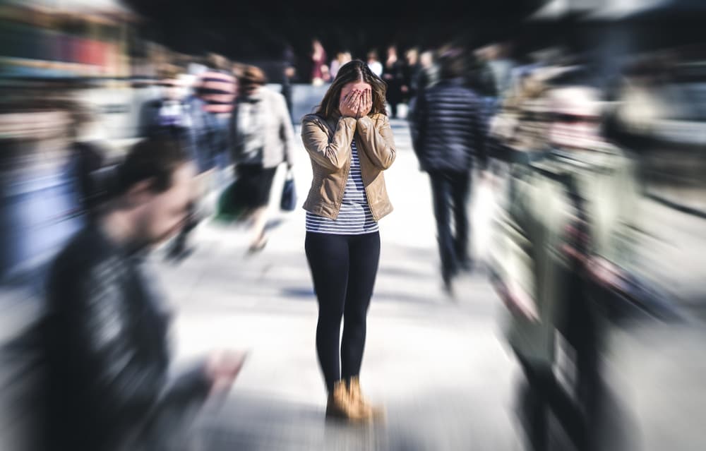 A lady in the middle of a busy crowd having a panic attack