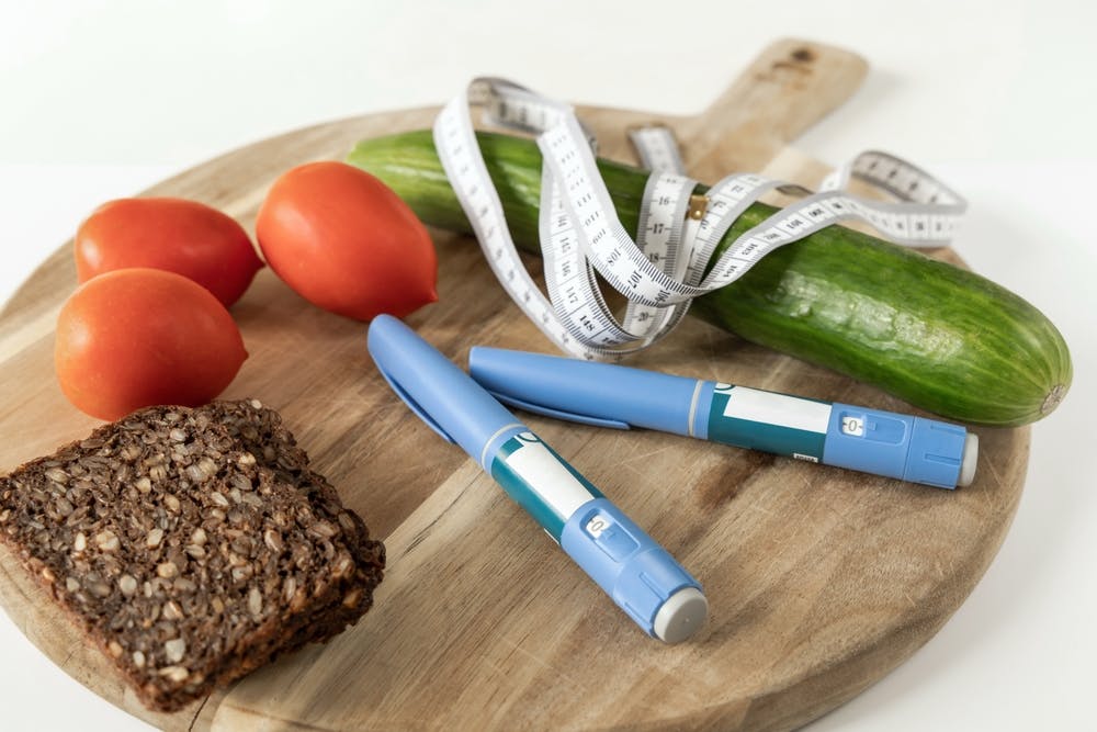 Weight loss injection pens next to healthy foods