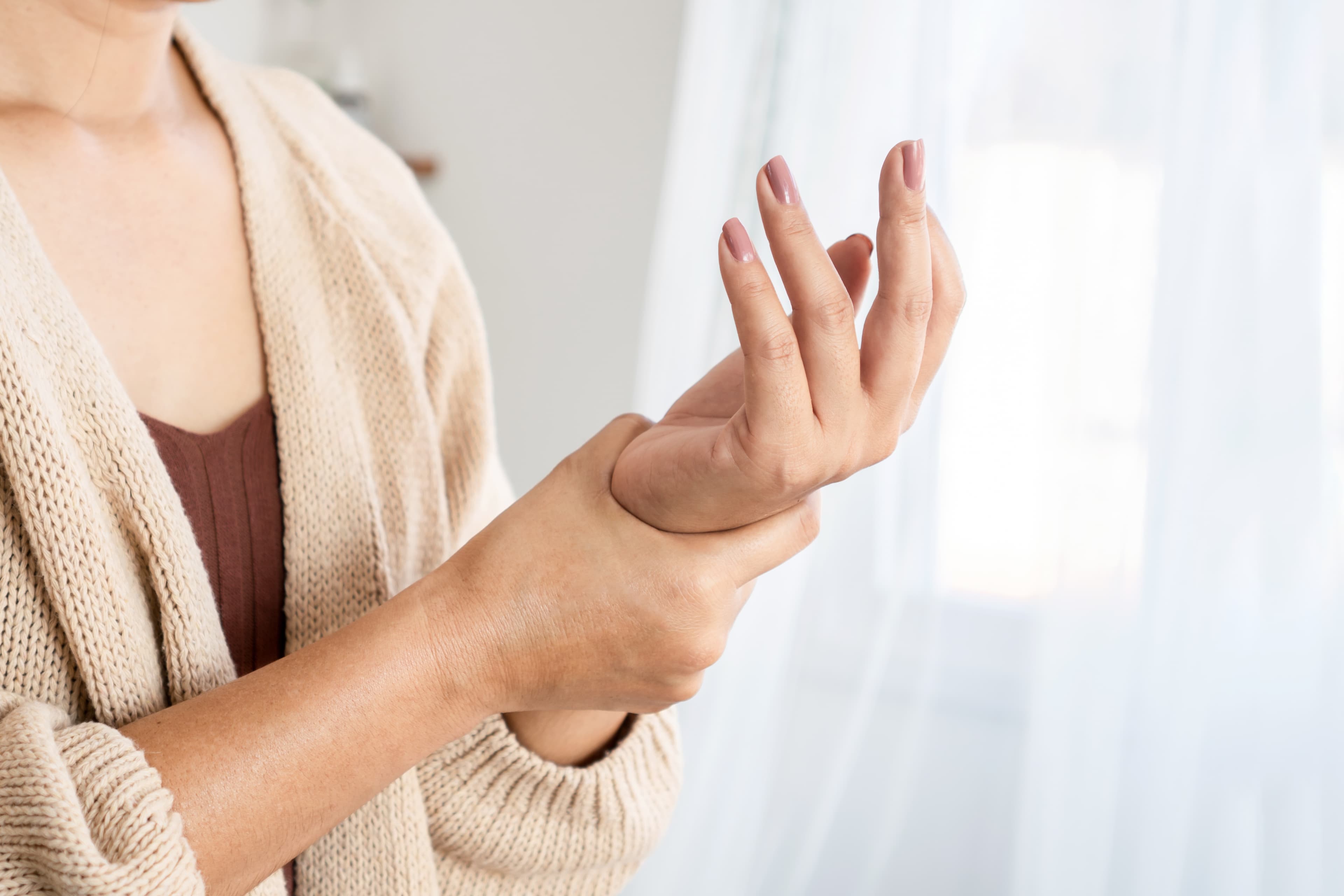 A lady holding her wrist due to experiencing gout