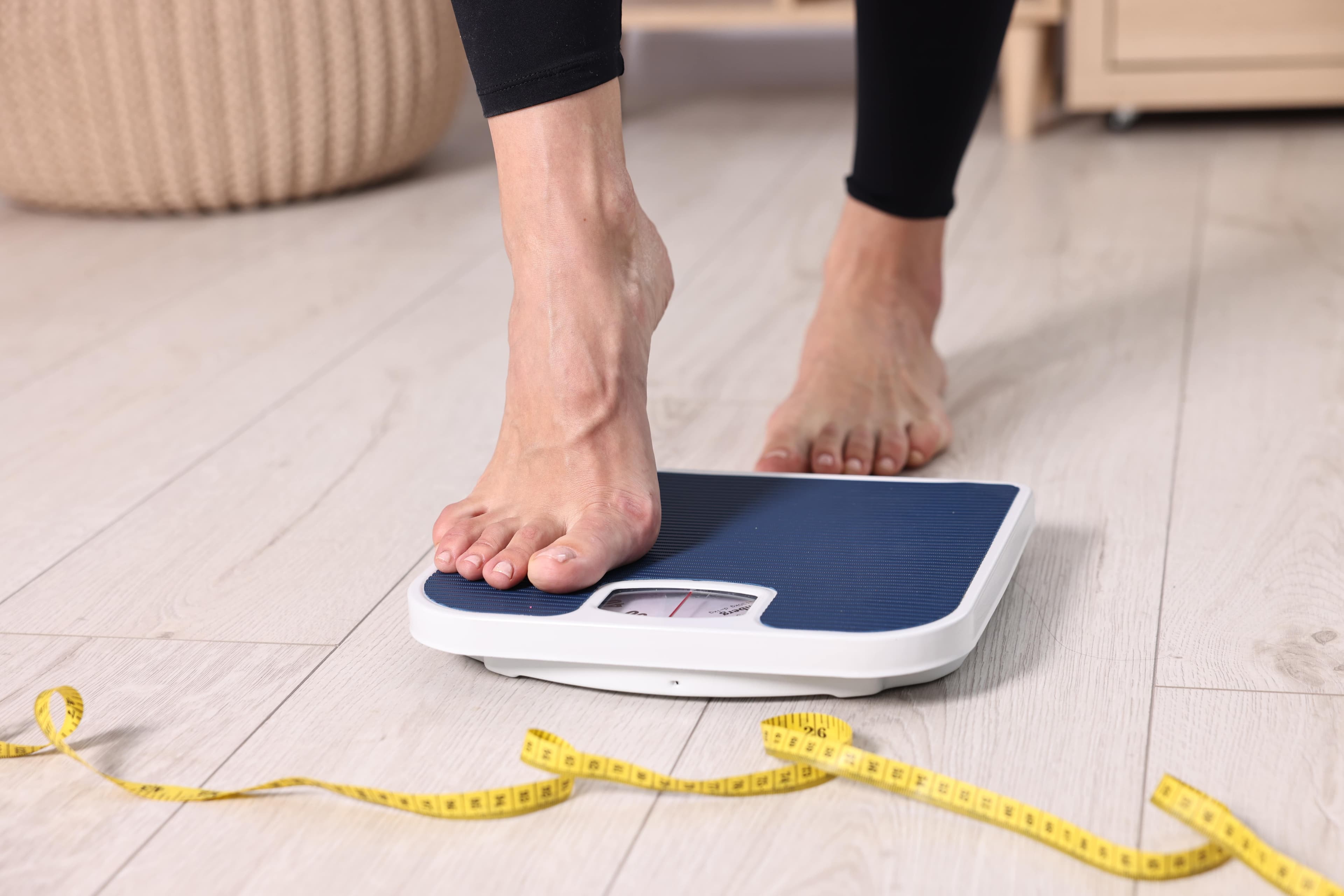 A pair of legs stepping on weighing scales